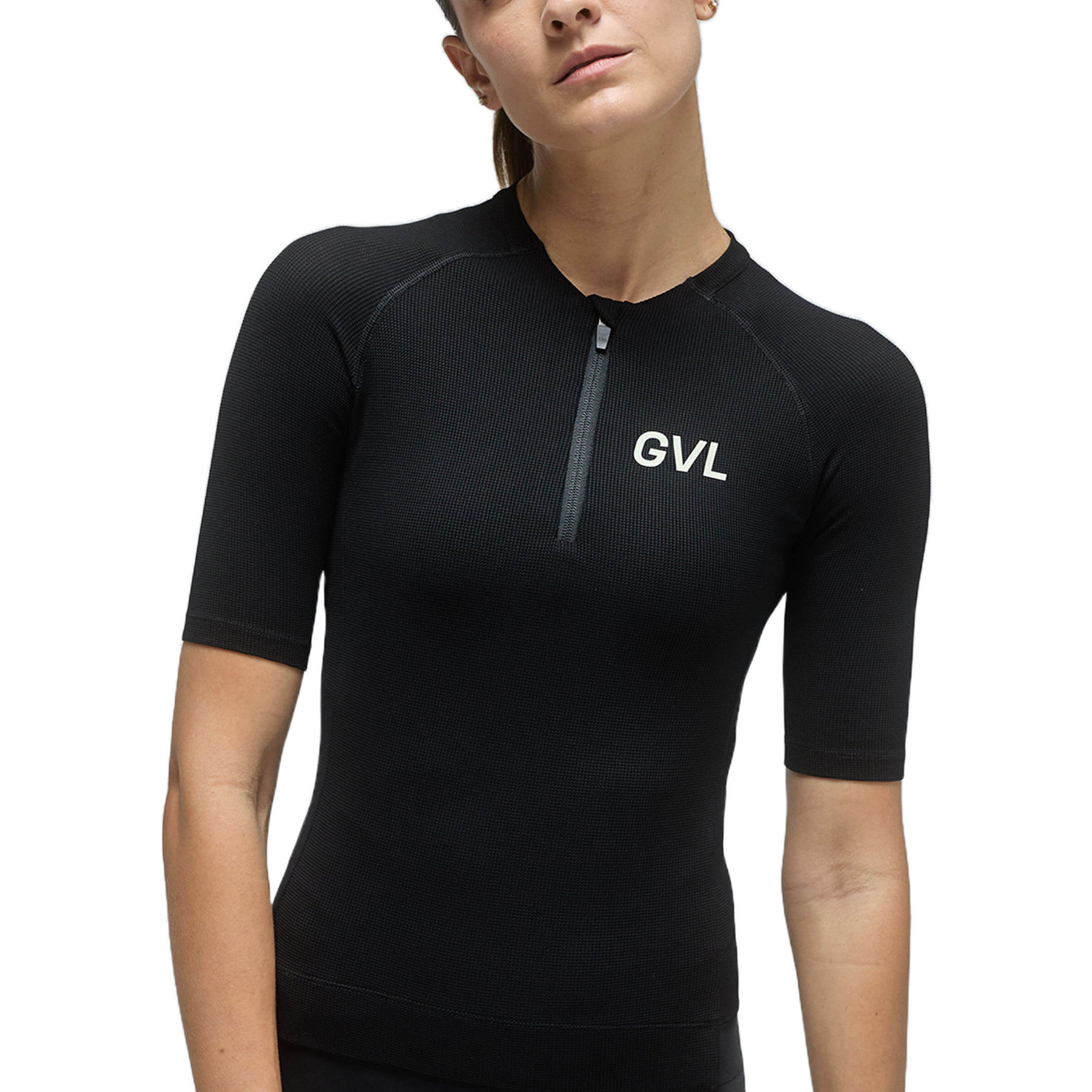 Front view of a woman wearing a black Givelo Modern Classic jersey, demonstrating the half-zip feature, snug fit, and the 'GVL' logo that represents the brand's commitment to breaking the norms of cycling apparel.