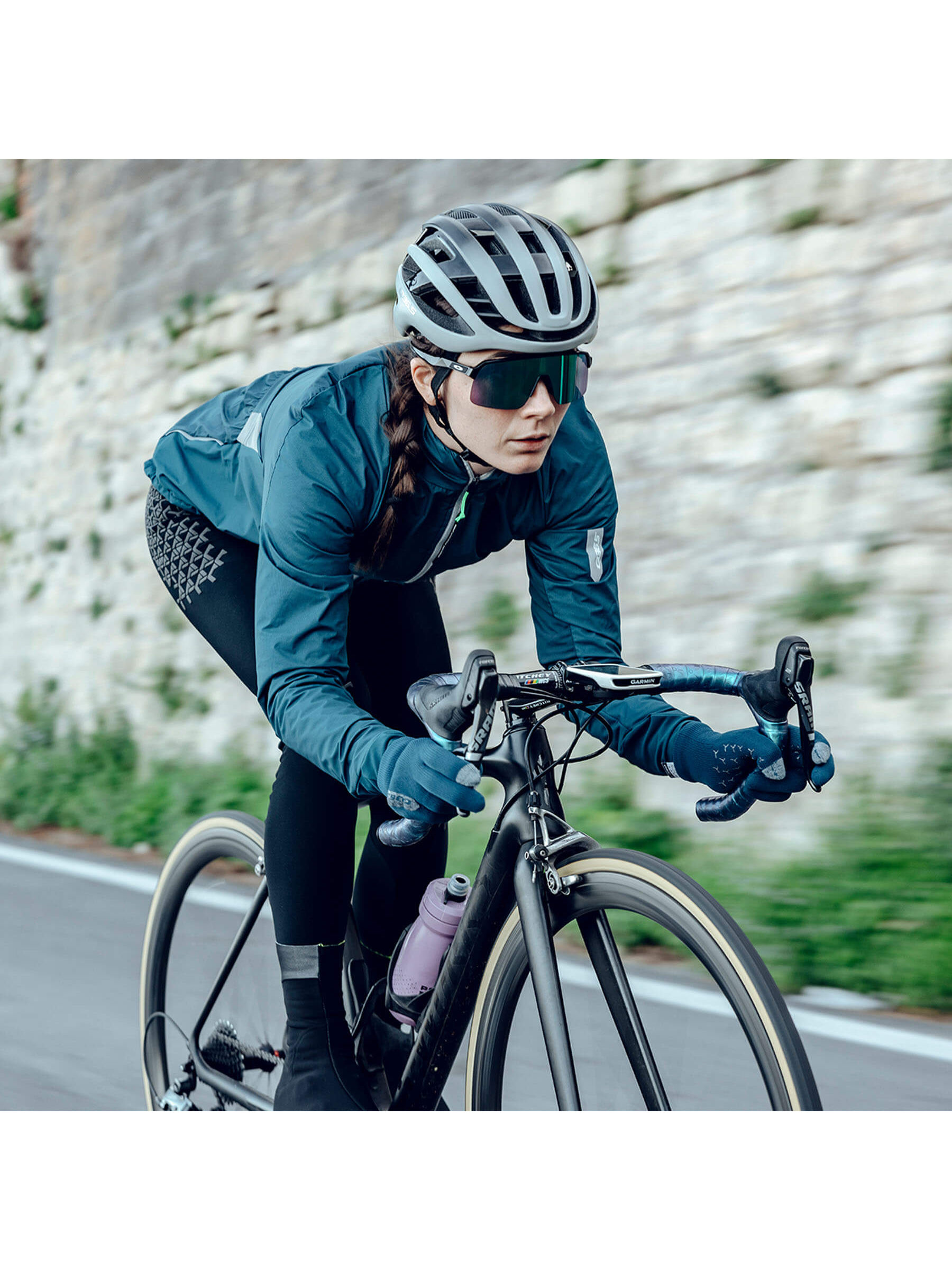 Female cyclist in action wearing Q36.5 Grid Skin Winter Bib Tights for warmth and protection.
