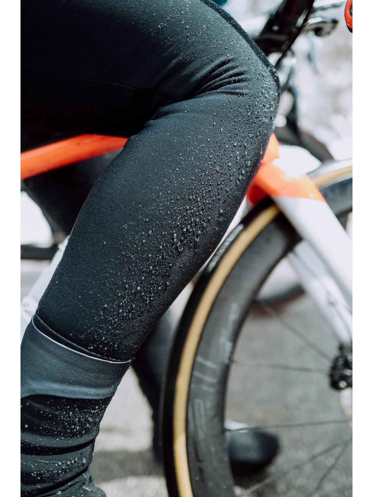 A cyclist in motion wearing Q36.5 Winter Bib Tights, illustrating the ergonomic fit and comfort during a snowy mountain ride.