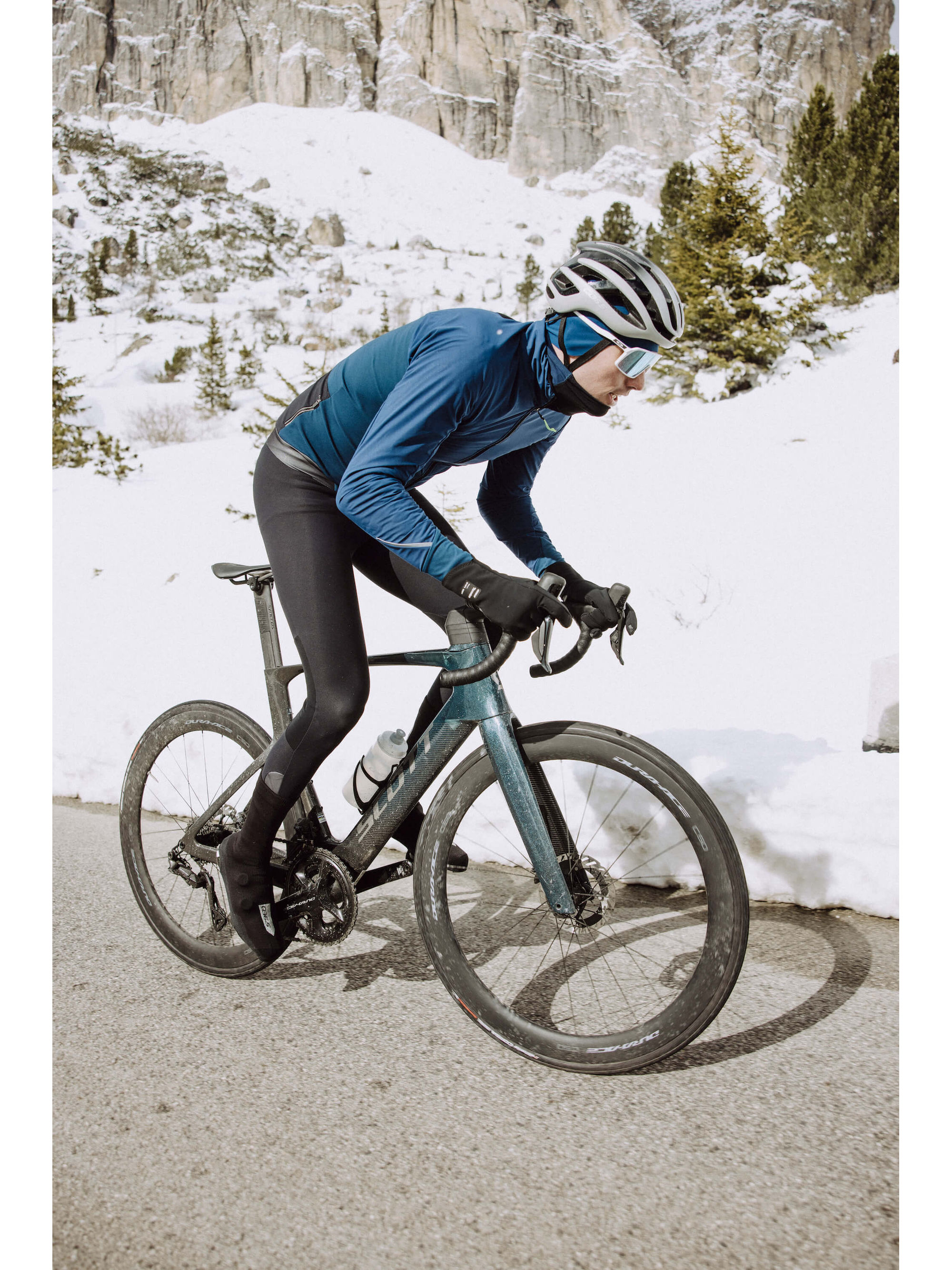 Side view of cyclist in Q36.5 Bib Tights showing the fit and fabric texture.