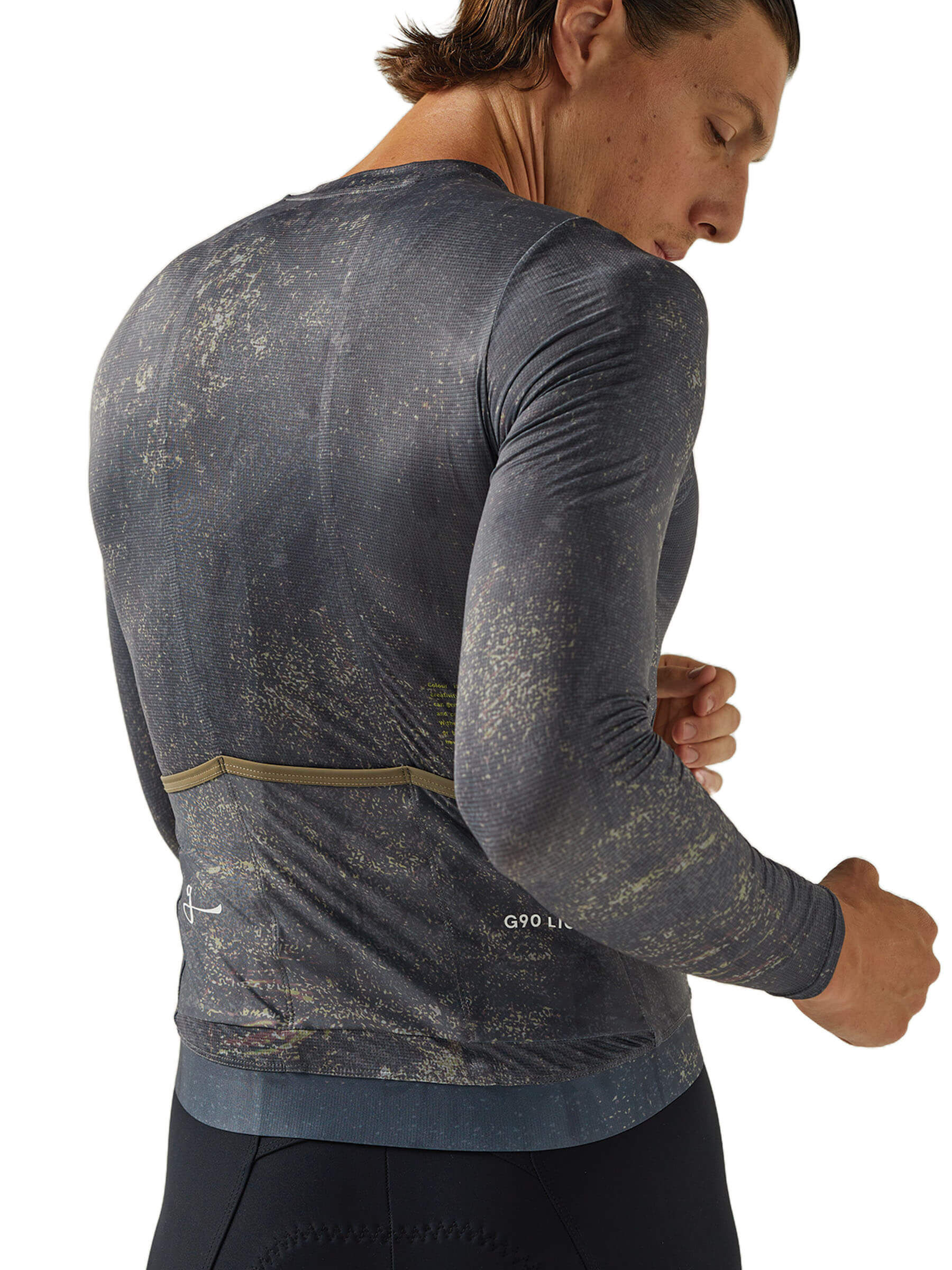 Male cyclist adjusting a dark Givelo G90 long sleeve jersey, designed for summer comfort.