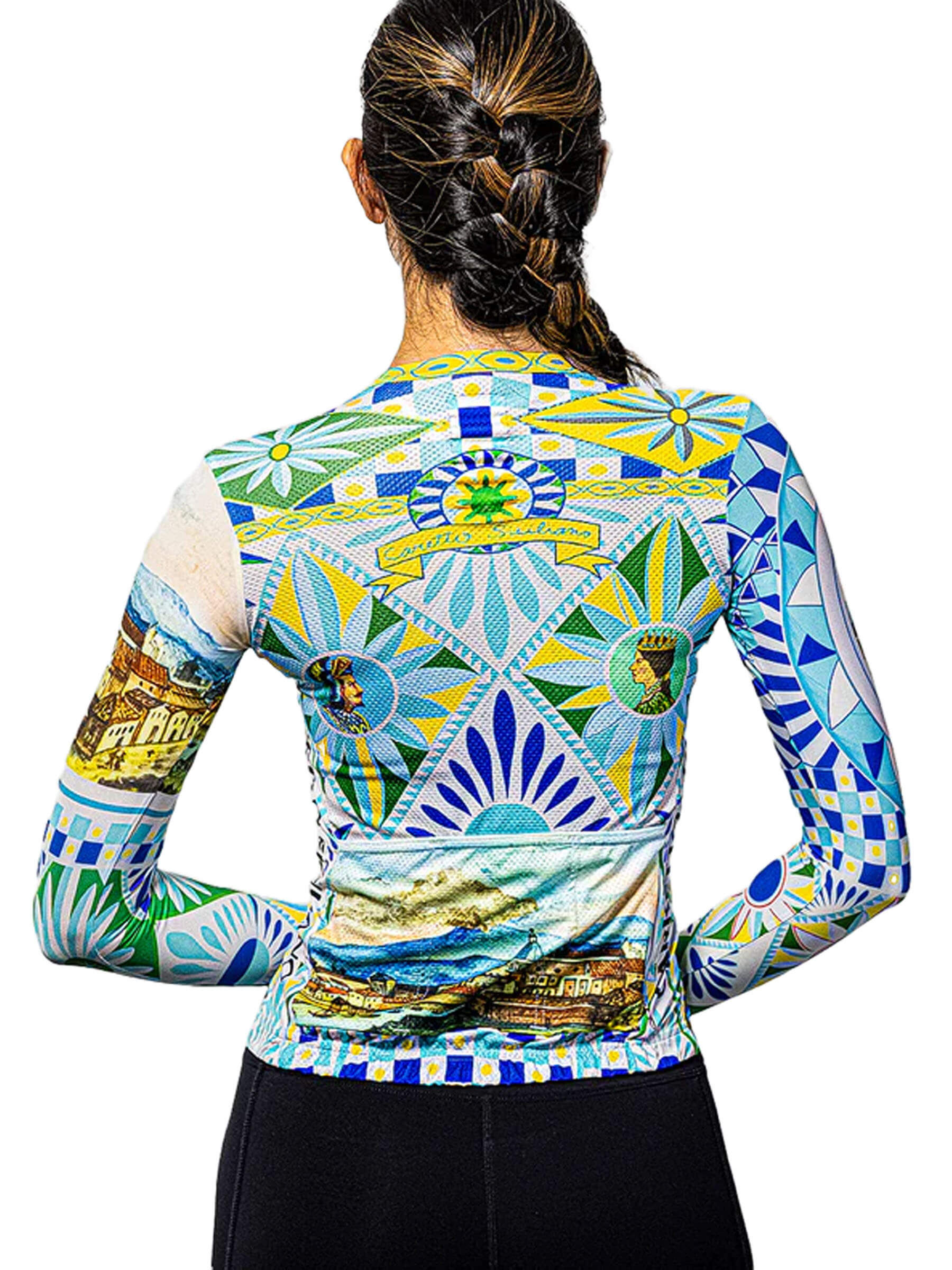 Full body view of a woman wearing the Ostroy Carretto jersey, with a background highlighting the jersey's design that echoes art from around the world.