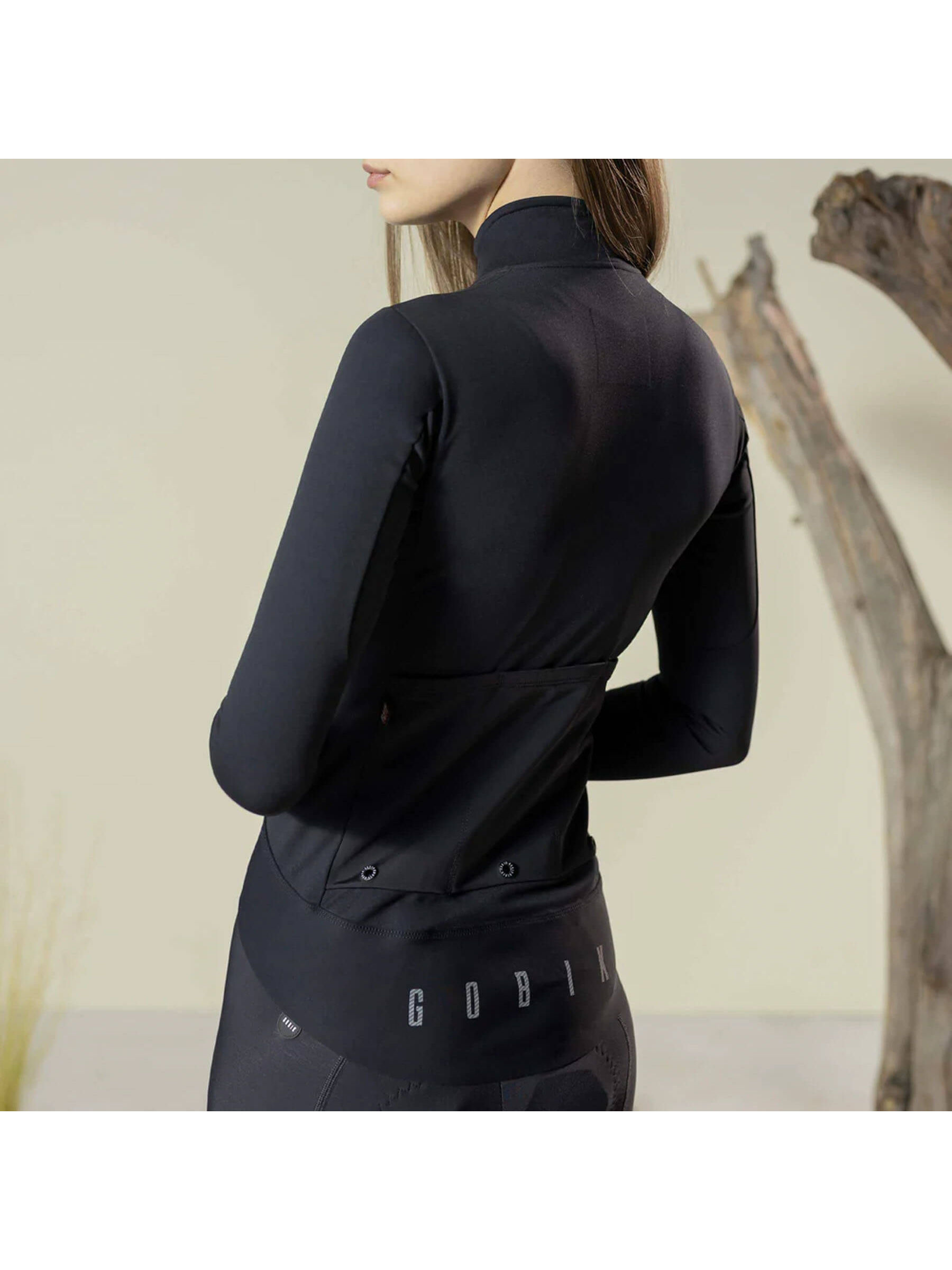 Woman wearing GOBIK Envy Jacket, showcasing its form-fitting design and arm flexibility.