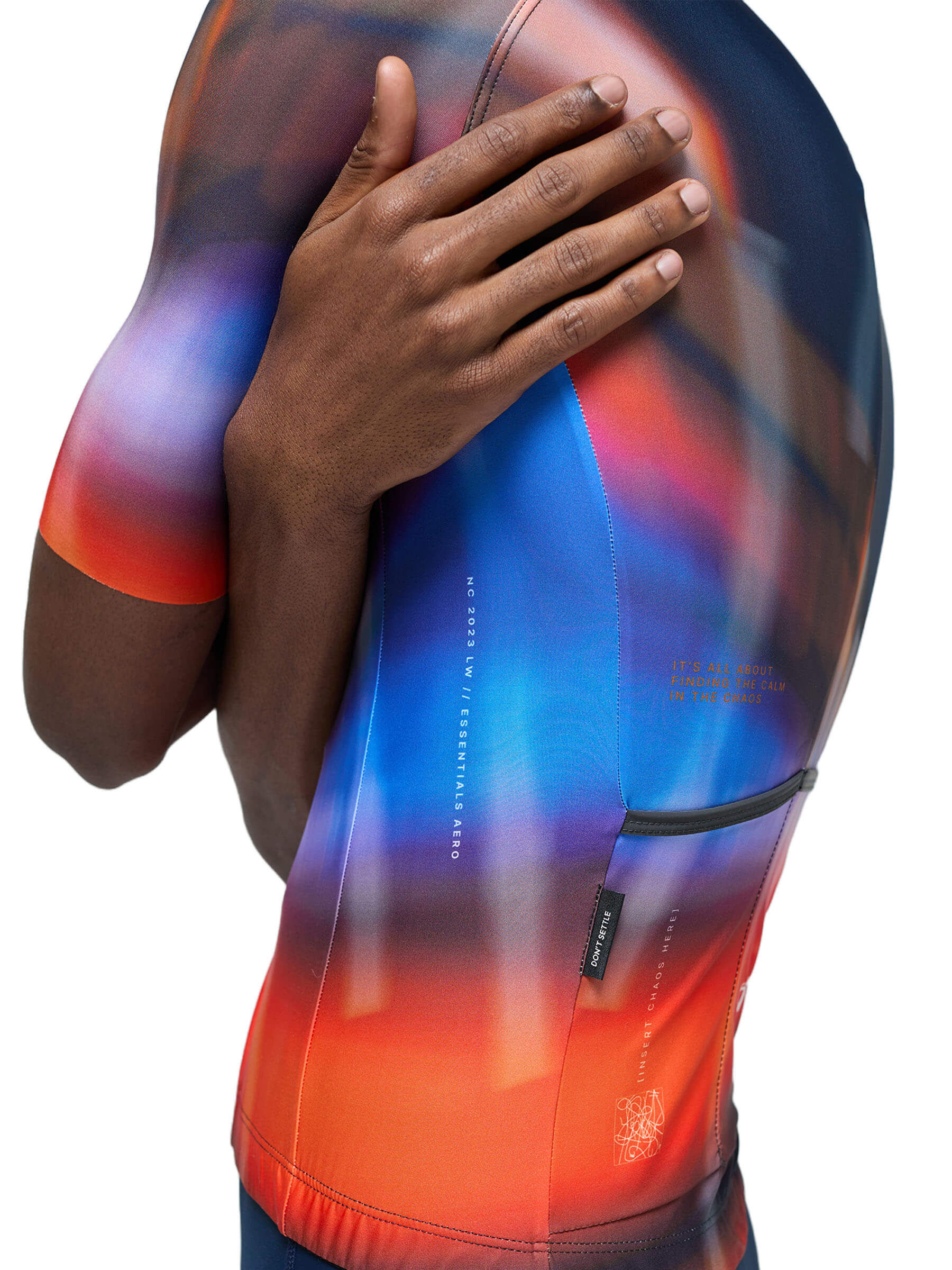 Close-up of the Givelo Essentials Chaos cycling jersey with vibrant red to blue gradient and text detail.