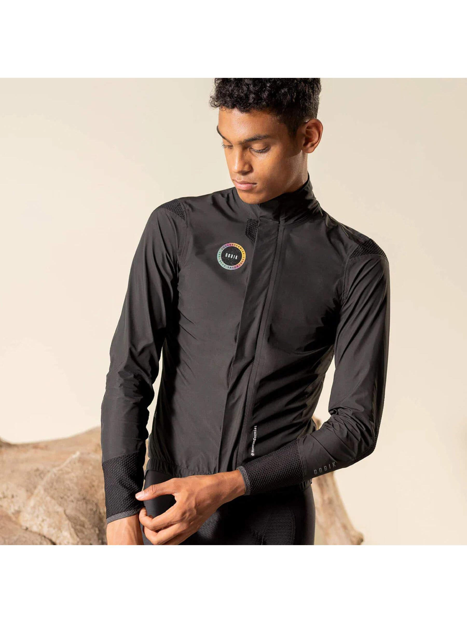 Cyclist in the EXO Royal Black jacket, demonstrating the waterproof and windproof features and snug fit.