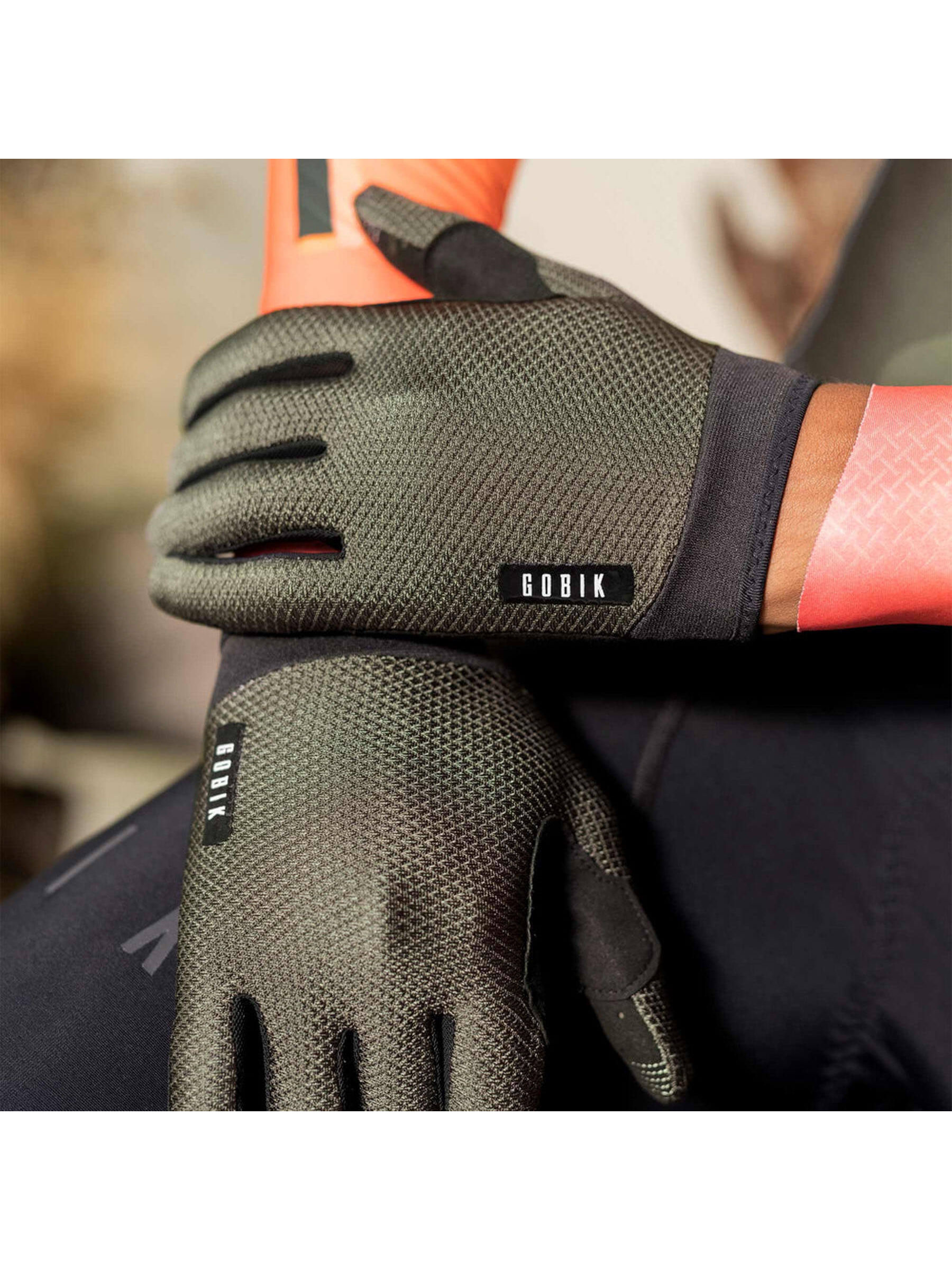 Close-up of a cyclist wearing GOBIK Lynx Gloves in army green, demonstrating grip on bike handles.