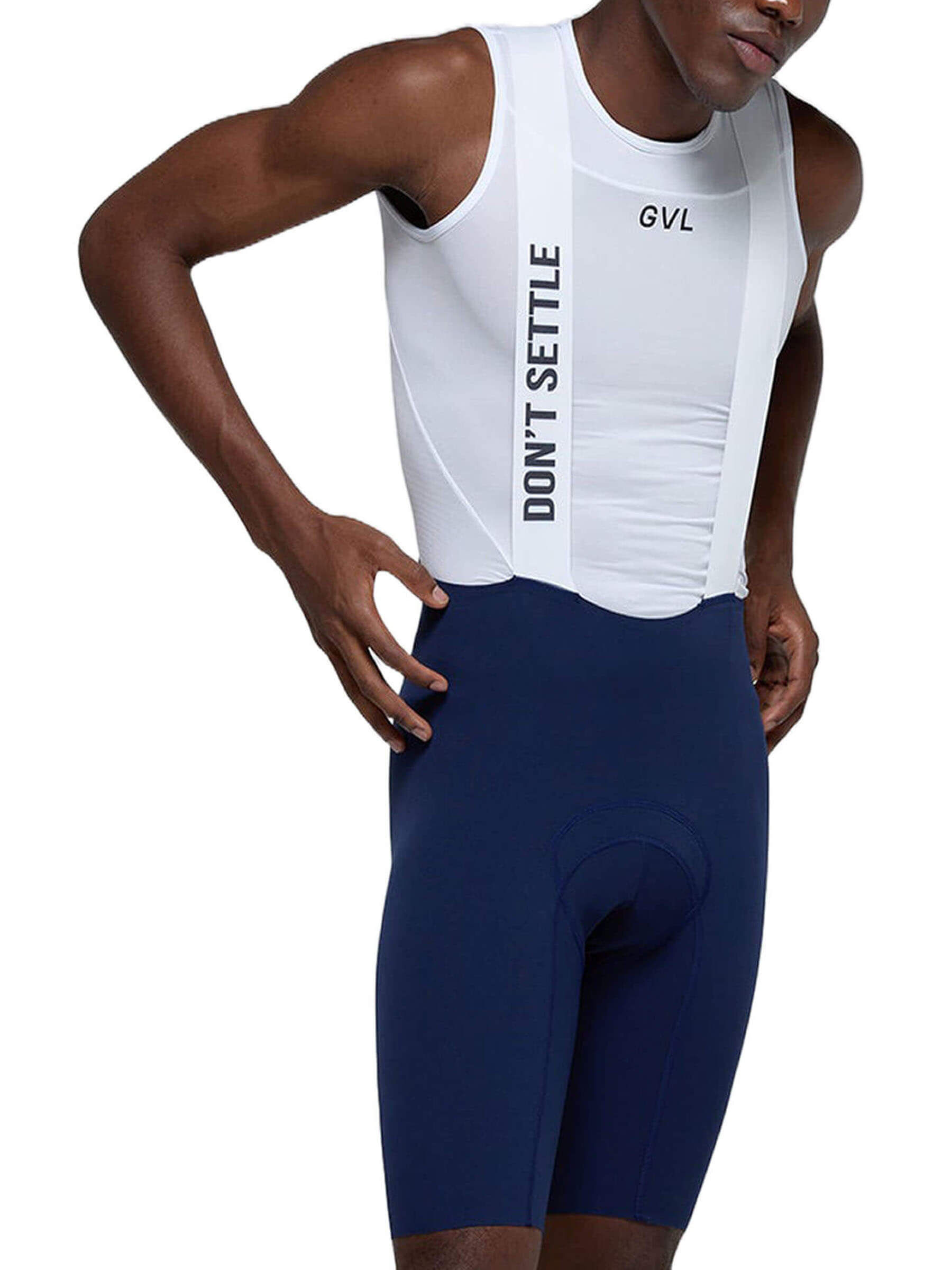 A man posing to the side with his hand on his hip, wearing white Givelo Mayfly bib shorts with a 
