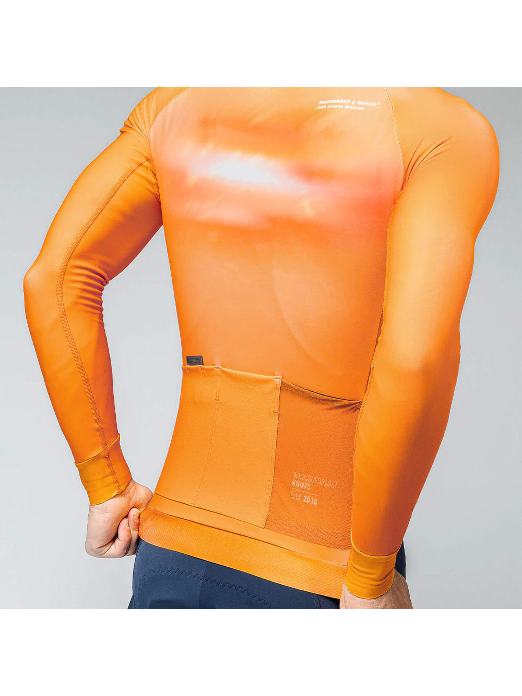 Rear view of a man in a cheddar-colored GOBIK Hyder jersey, with back pockets and side mesh for essentials.