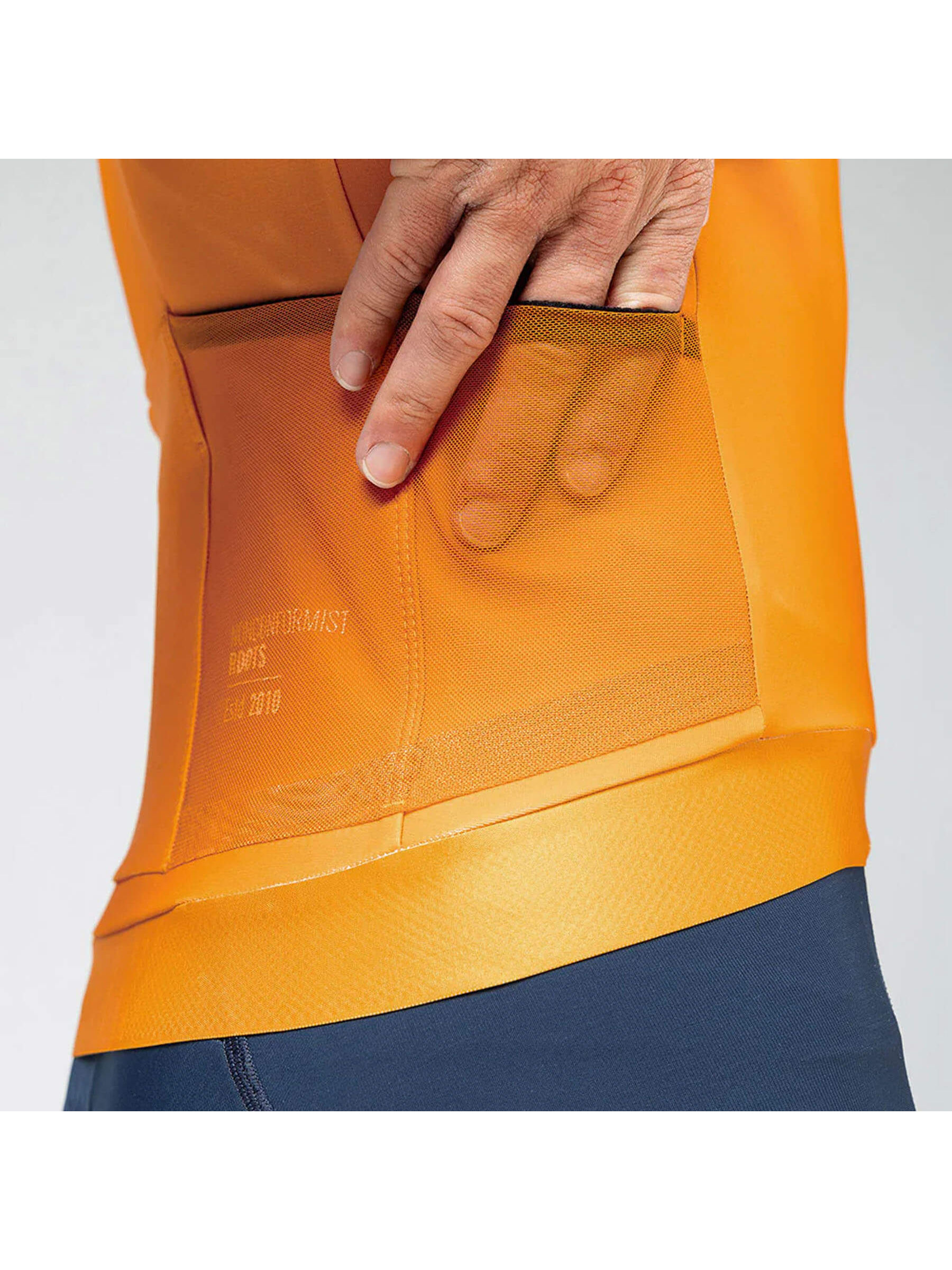 Rear view of a man in a cheddar-colored GOBIK Hyder jersey, with back pockets and side mesh for essentials.