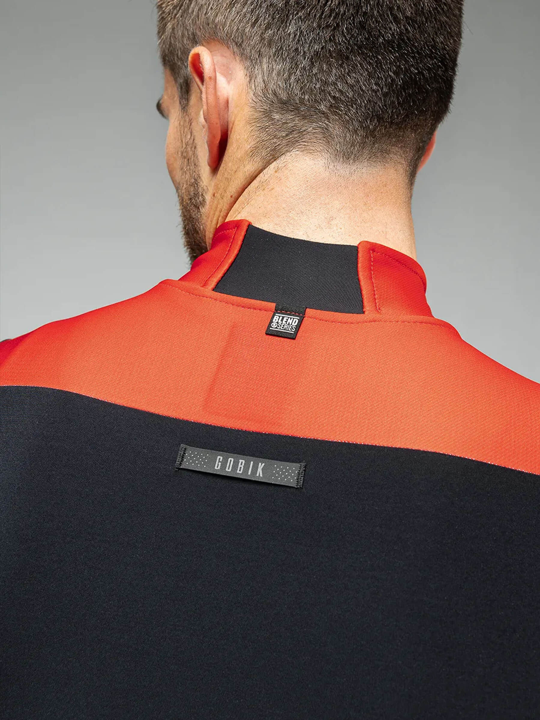 A cyclist wearing a red and black jacket with eVent® DVstretch™ insulating membrane for optimal wind resistance and aerodynamics.