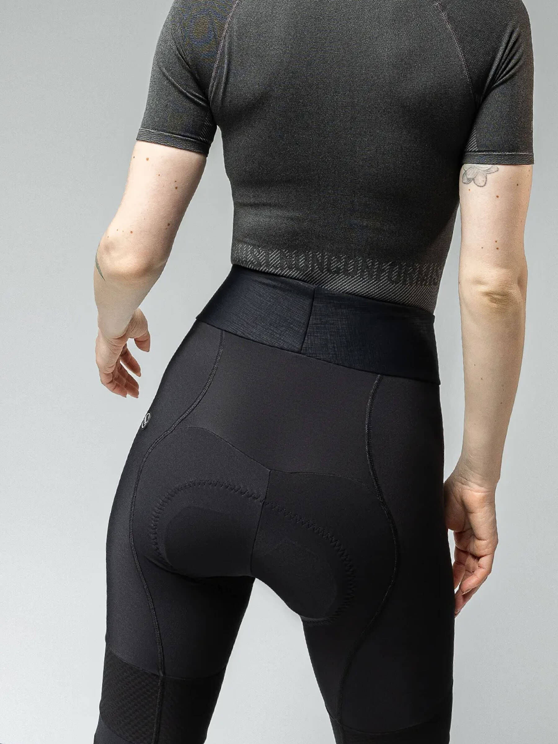 Woman in Gobik Absolute 6.0 Strapless Cycling Tights featuring high-waist design and textured patterns for visibility and comfort.