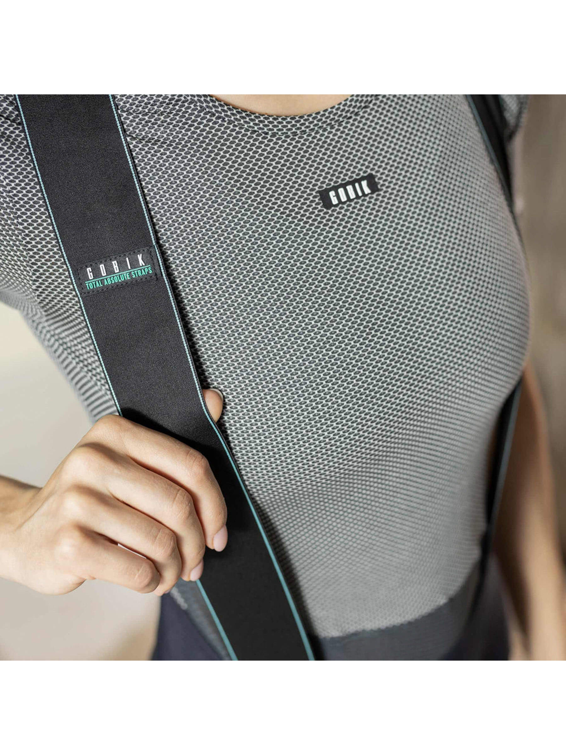 Close-up of the GOBIK base layer worn by a woman, focusing on the upper chest area with the brand logo and the mesh fabric's hexagonal texture for breathability.